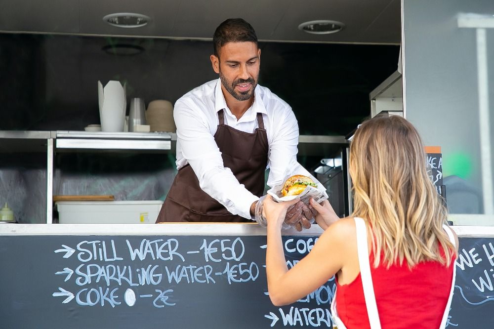 Employee handing a burger | building customer trust